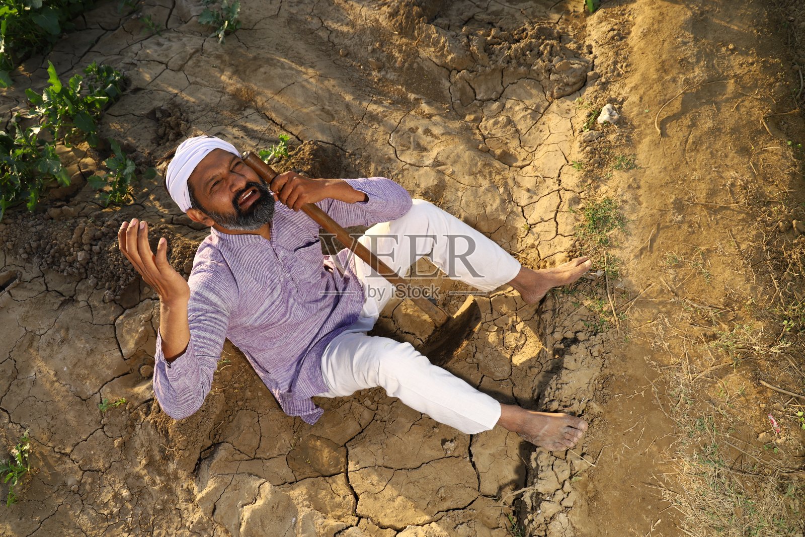 悲伤的印度农民哭着为他的农场祈祷。照片摄影图片