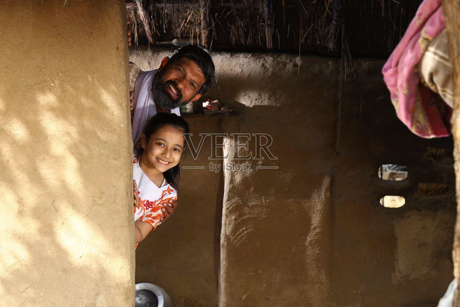 快乐的印度父亲和女儿一起玩捉迷藏。照片摄影图片