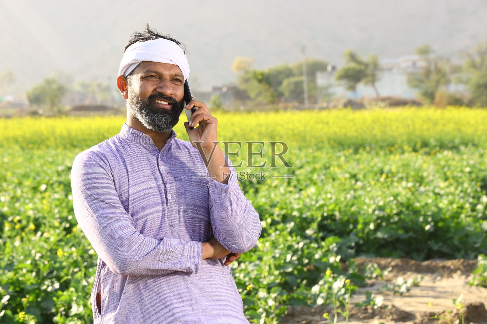 快乐的印度农民在打电话。照片摄影图片