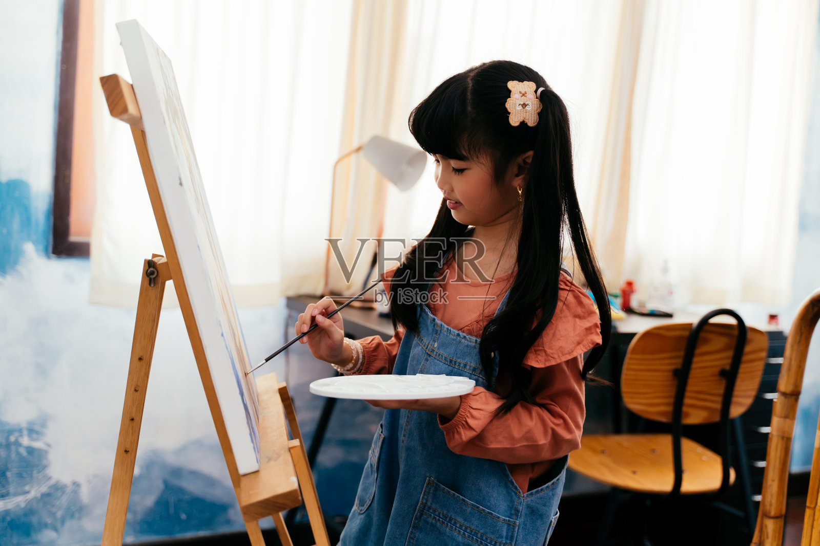 亚洲女孩在家里的画布上画画照片摄影图片