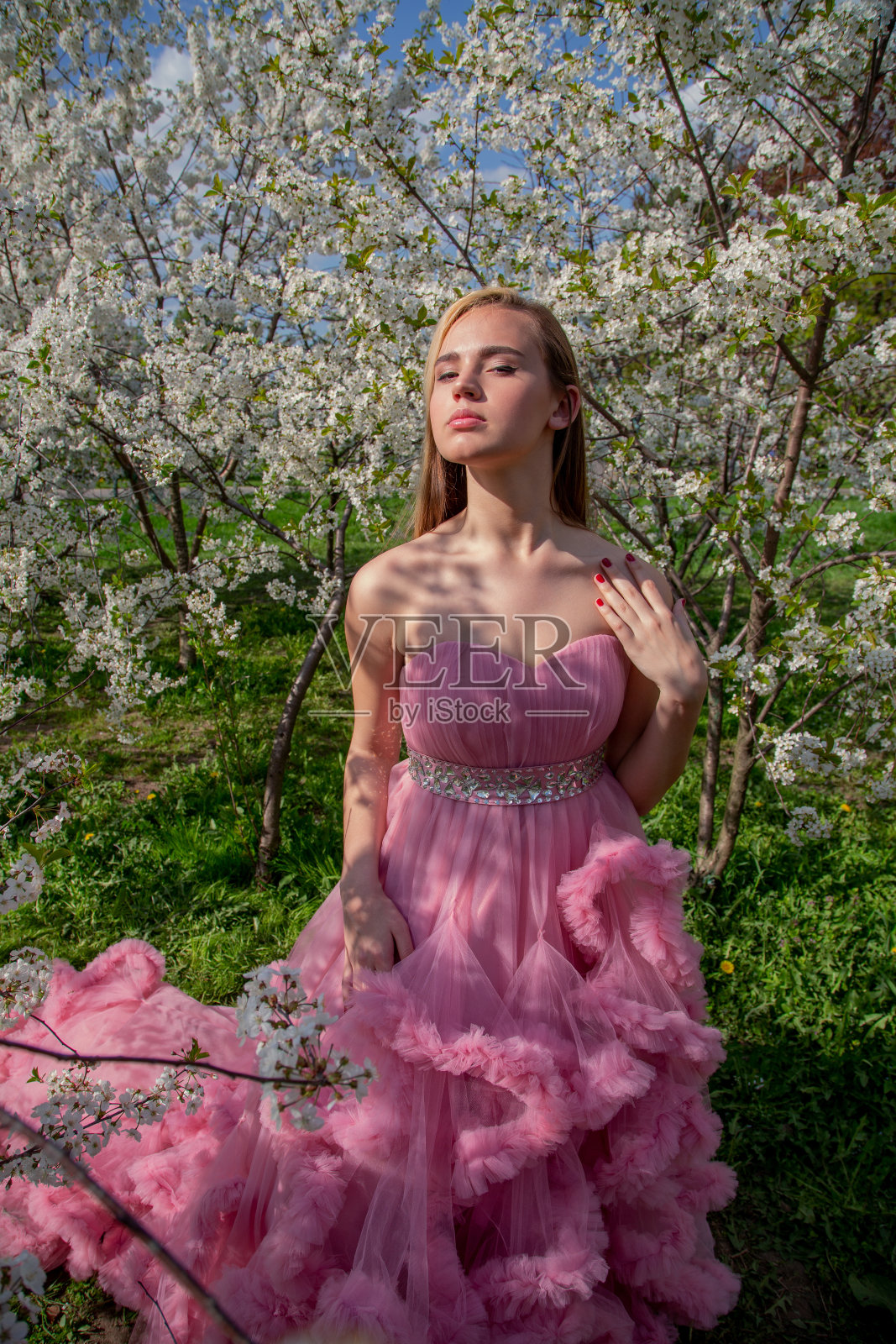 一个亚洲女孩的肖像在一个盛开的花园。开花的树。照片摄影图片