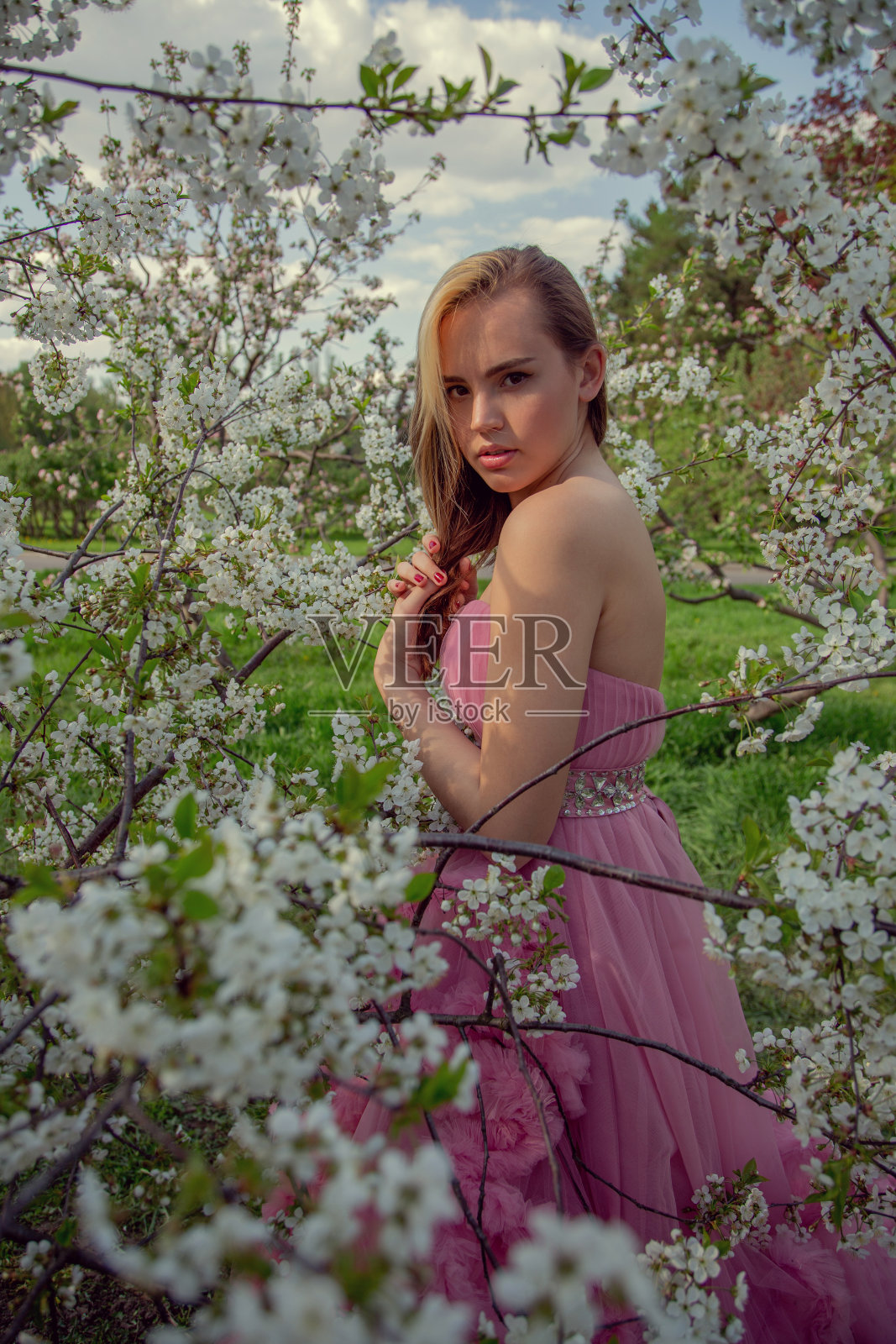 一个亚洲女孩的肖像在一个盛开的花园。开花的树。照片摄影图片