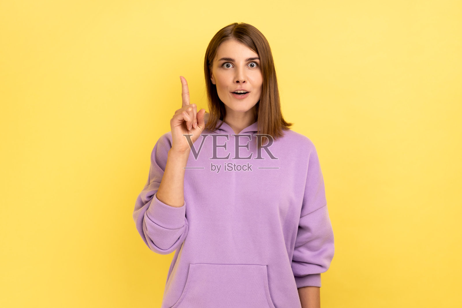 女人竖起手指，灵光一现，一脸惊讶。照片摄影图片