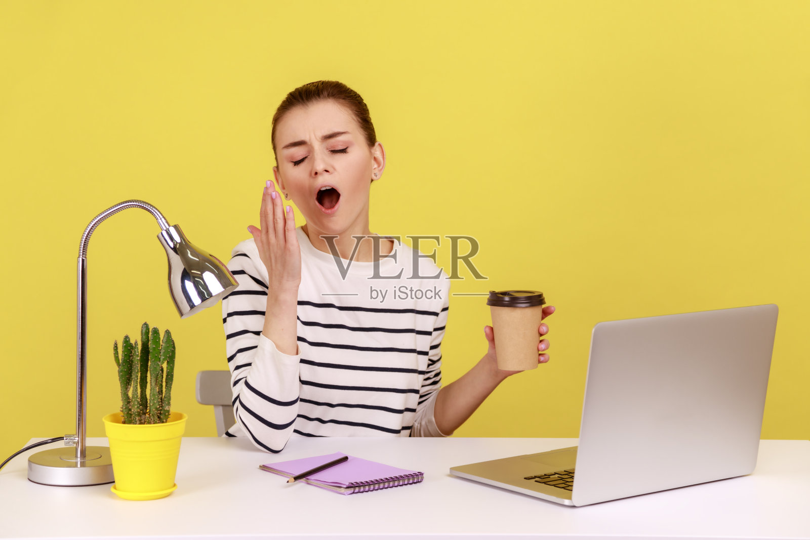 女秘书打呵欠，渴望睡觉，感到疲惫和压力，正在喝咖啡照片摄影图片