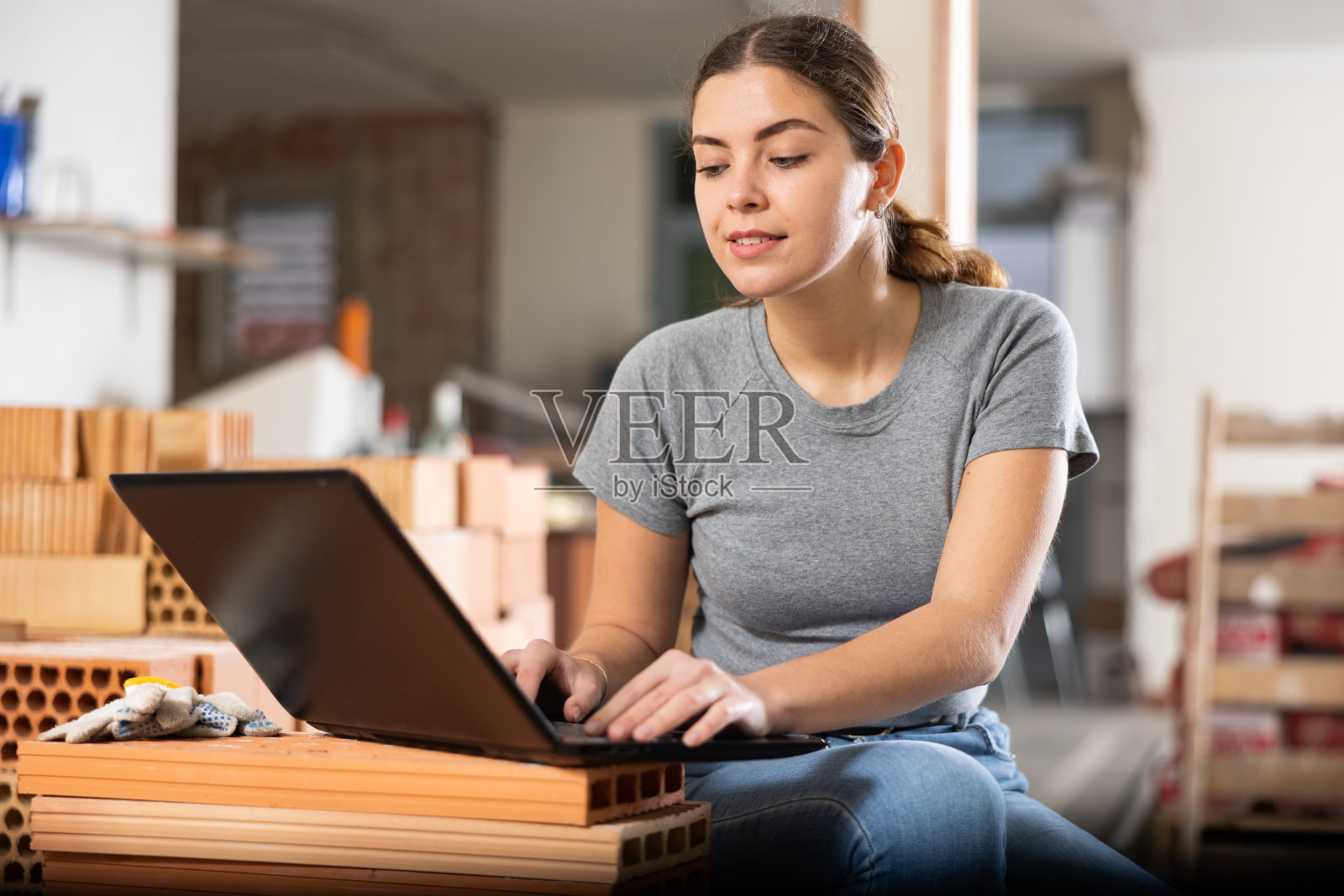 一名女子带着笔记本电脑在室内建筑工地照片摄影图片