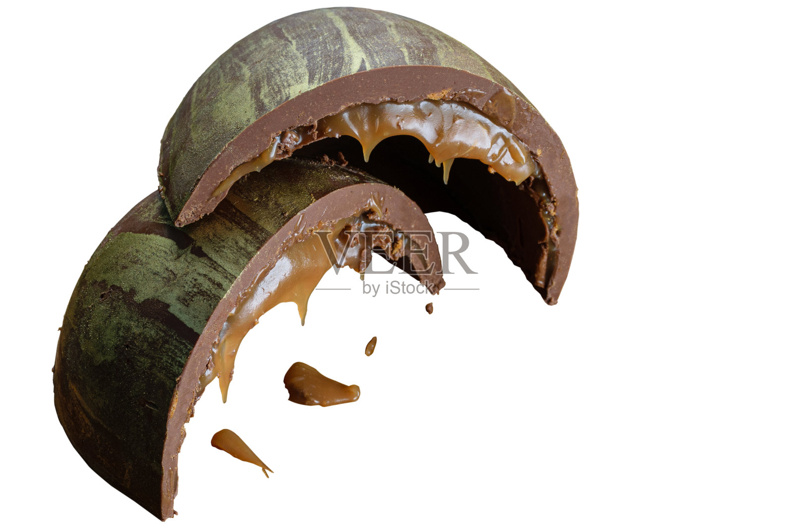 半个切成两层的复活节彩蛋，里面塞满了融化的焦糖和饼干，用可食用的金色颜料装饰。照片摄影图片