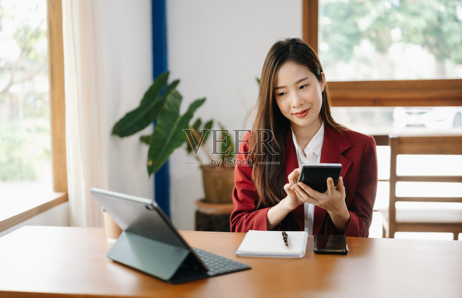 漂亮的亚洲商务女性打字笔记本电脑和平板电脑放在办公室的桌子上照片摄影图片