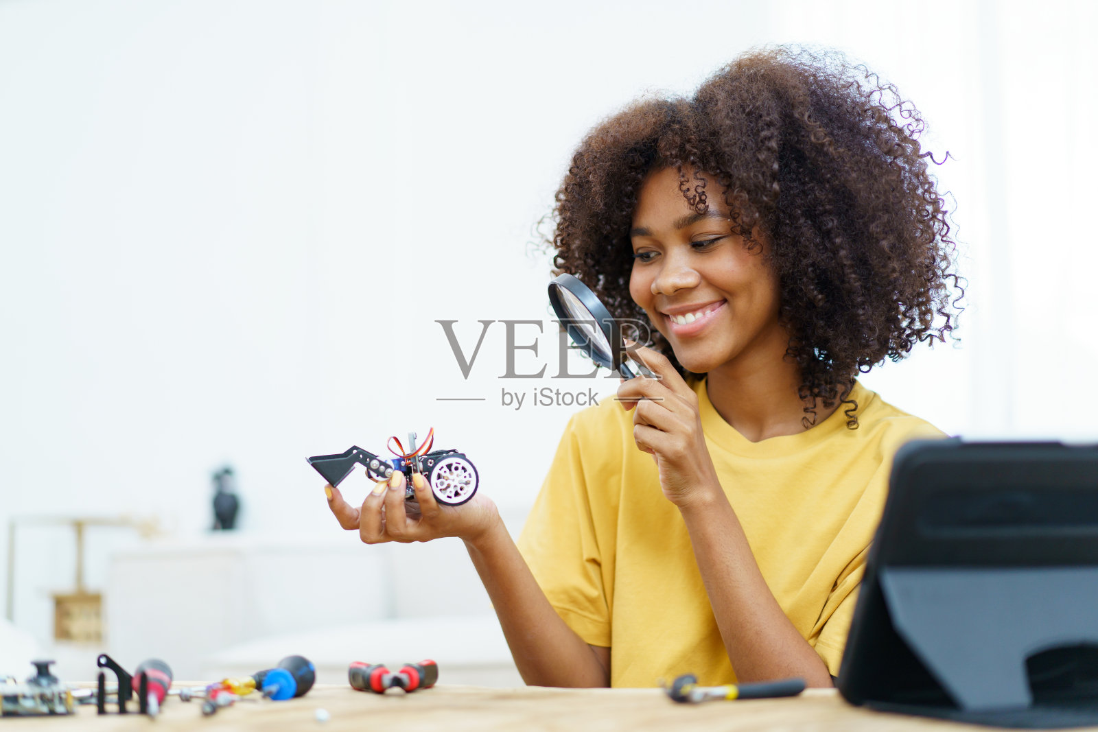 年轻女子组装机器人。照片摄影图片