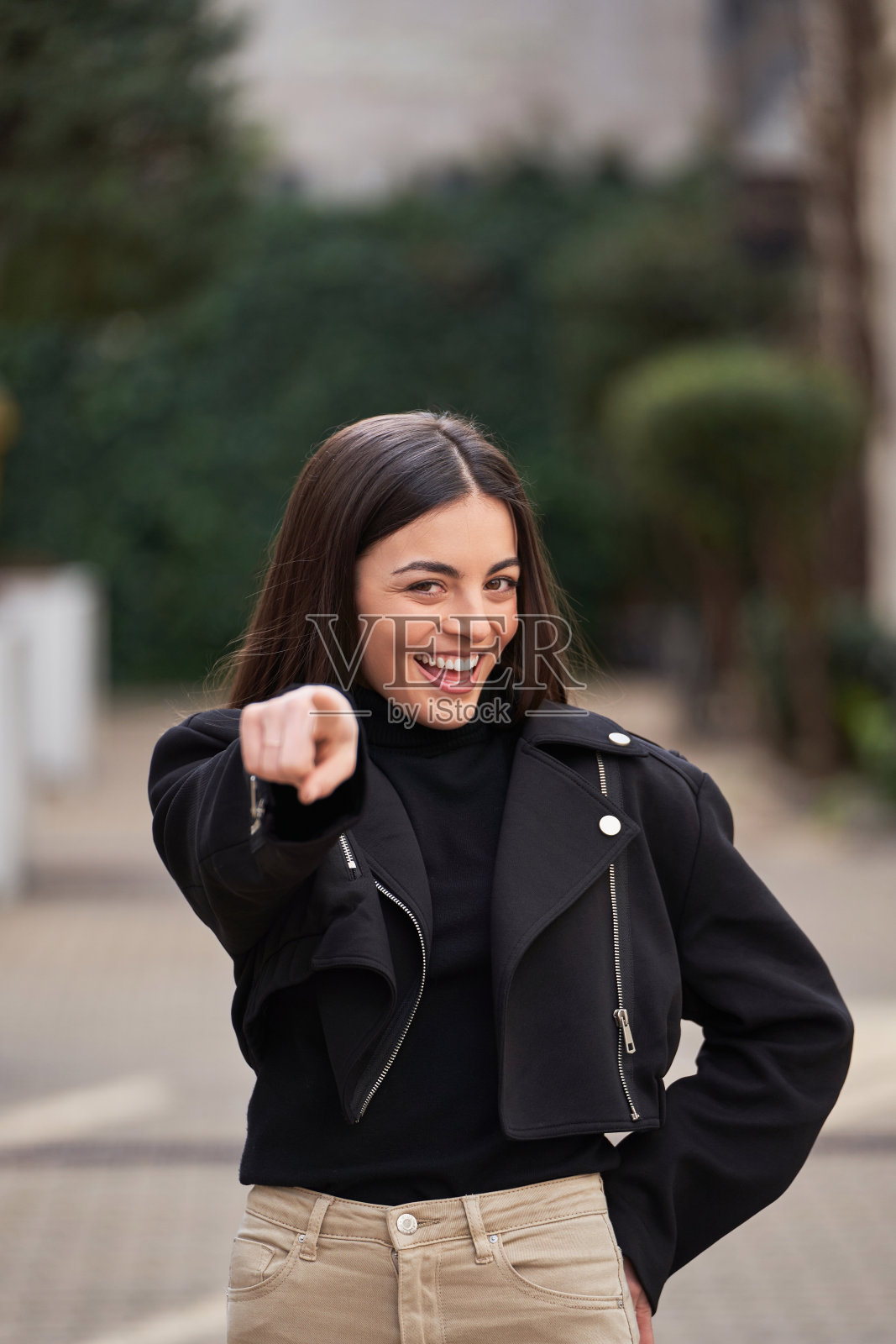 女人指着相机微笑。照片摄影图片