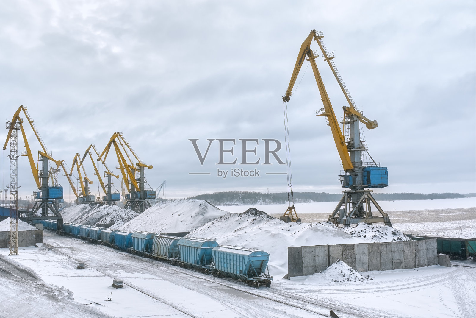 冬季装载起重机和货车的货物港口视图。照片摄影图片