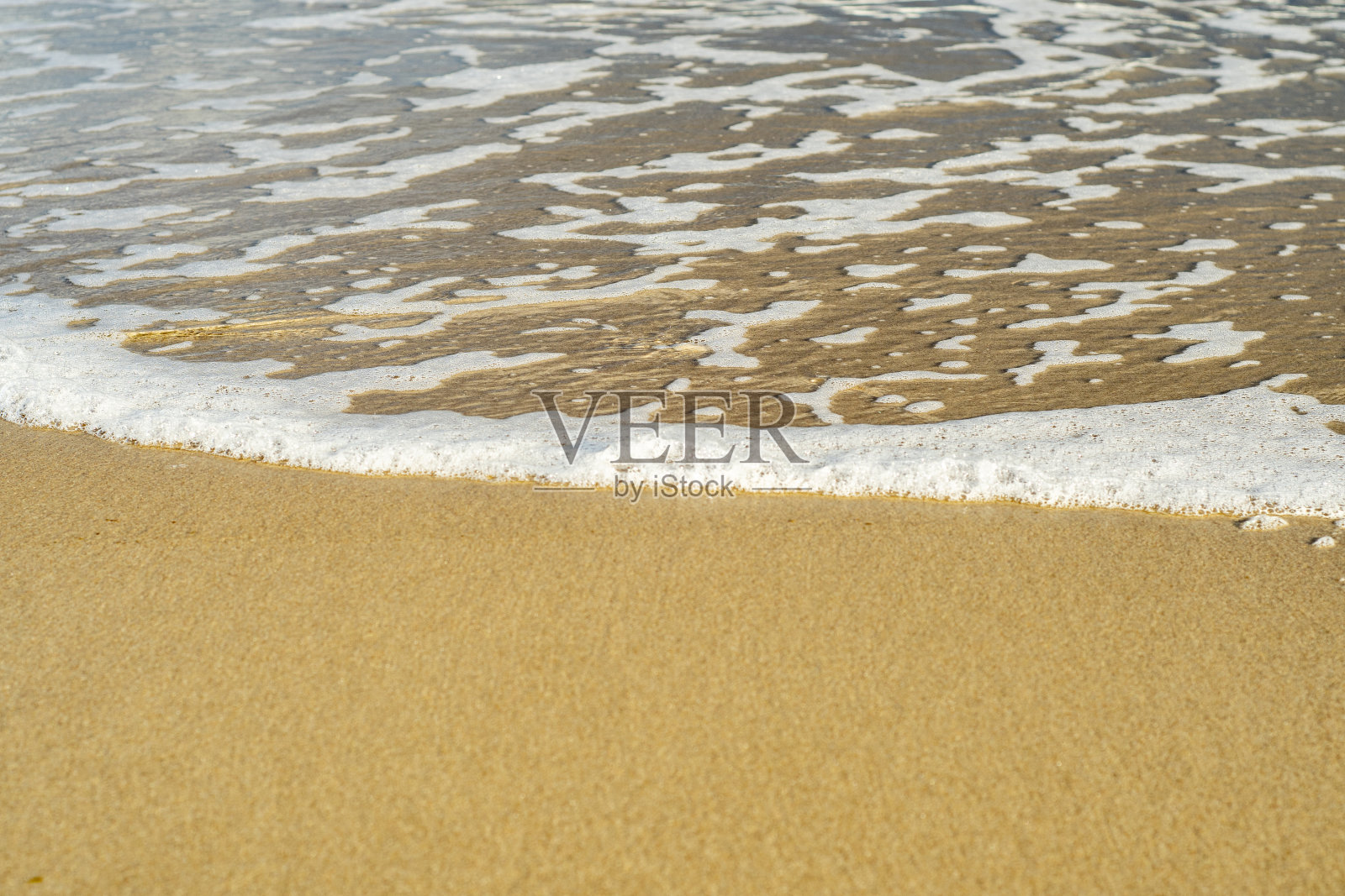 一个透明的海浪沙滩特写。夏日的海边。照片摄影图片