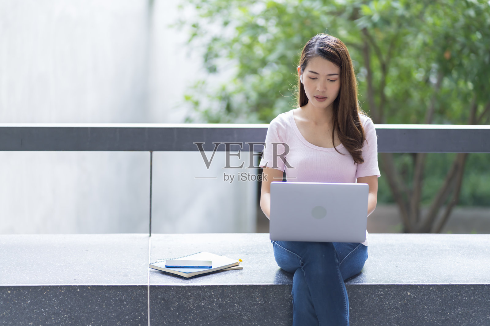 亚洲女学生在大学附近学习备考。通过连接到互联网的手机或笔记本电脑进行交流。知识来源丰富照片摄影图片