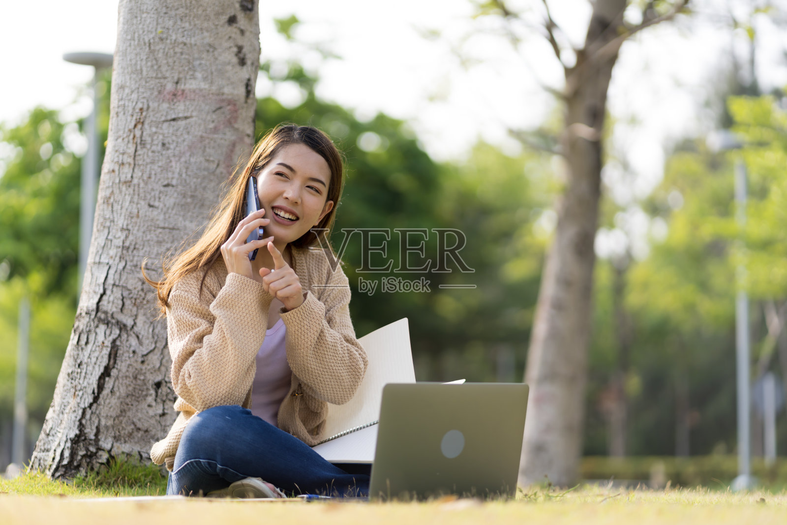 亚洲女学生在大学附近学习备考。通过连接到互联网的手机或笔记本电脑进行交流。知识来源丰富照片摄影图片