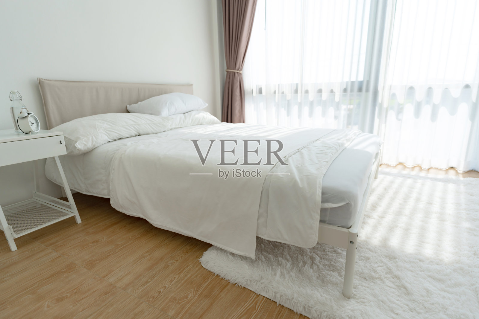 白色的卧室，白色的窗帘和白色的枕头照片摄影图片