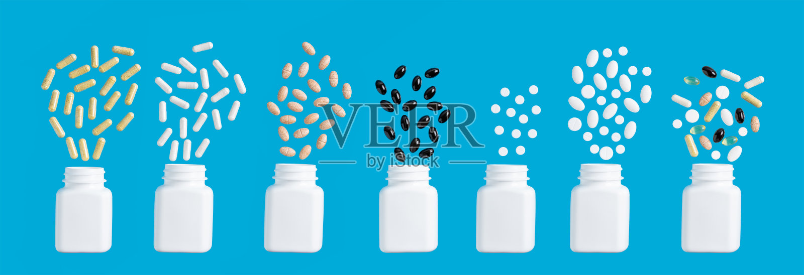 蓝色背景上的各种彩色胶囊、草药维生素丸或治疗药物的组成，医学和保健概念，俯视图照片摄影图片