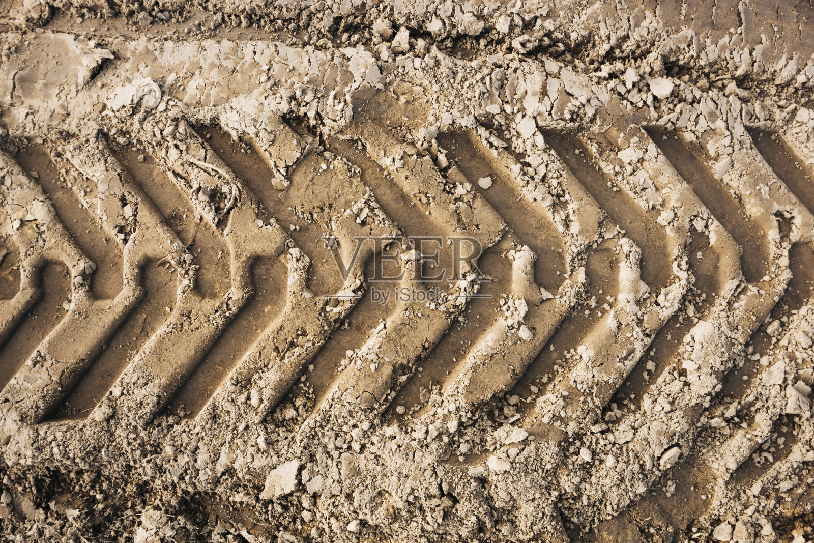 砂轮胎标记背景。轮胎履带形状。小径上有干棕沙图案。道路施工现场背景。重型机械印记。照片摄影图片