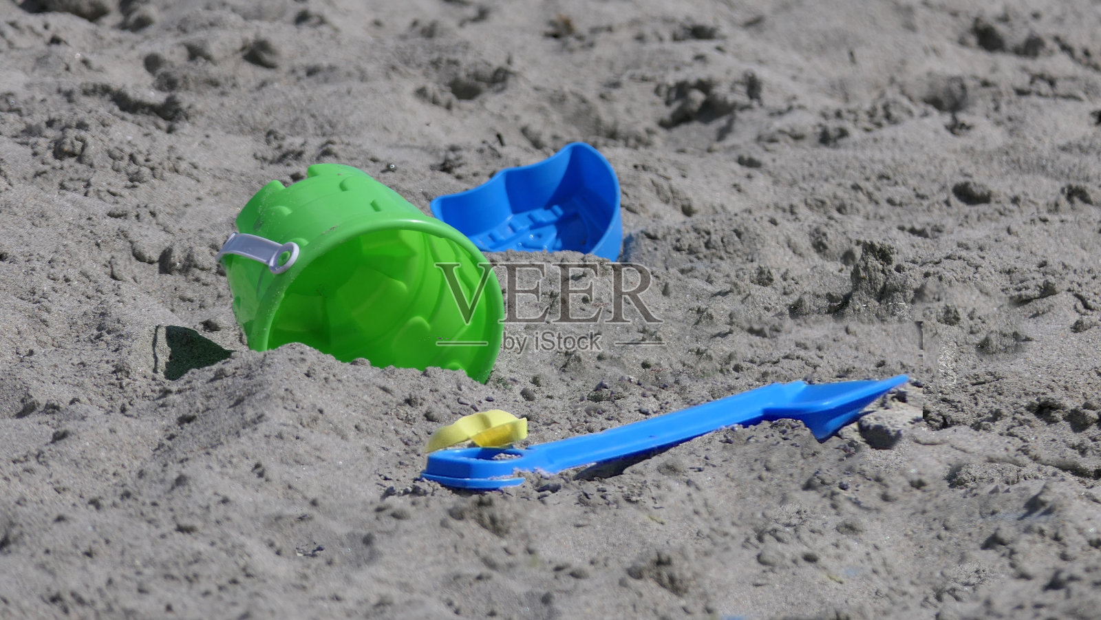 桶铲沙堡挖掘机玩具在沙滩与海浪在英国照片摄影图片