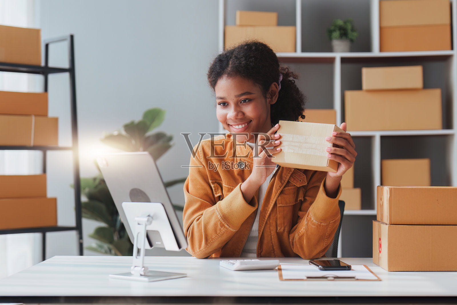 美国非洲裔企业家微笑着用平板电脑直播。成功的中小企业创业者概念照片摄影图片