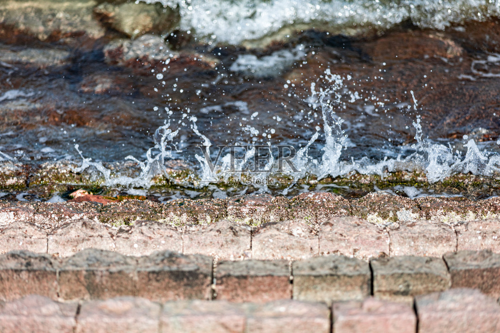 海浪拍打着海岸，溅起水花照片摄影图片