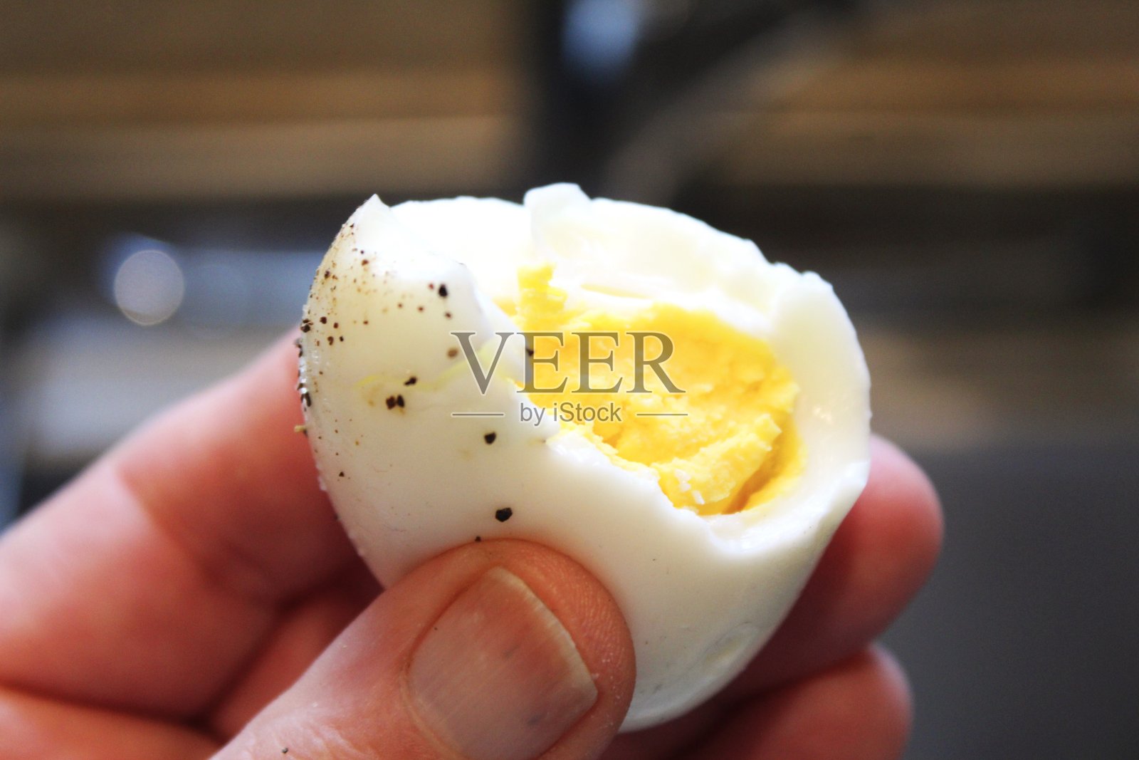 免版税的照片-网站，美食博客，菜单或广告的最佳食物背景-吃美味的煮鸡蛋与盐和胡椒的早餐-吃一口煮熟的-早餐咬的特写-在我手里拿着鸡蛋照片摄影图片