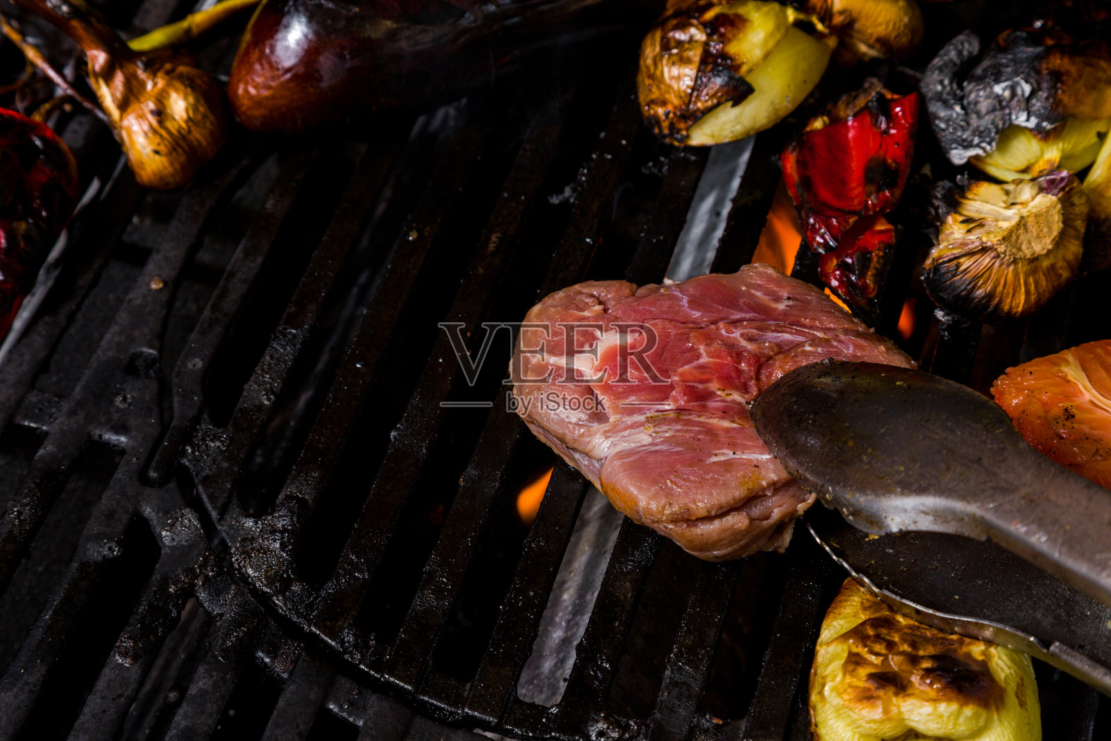用迷迭香、大蒜、洋葱、胡椒粉、蘑菇、西葫芦、西红柿在炭火上烤生猪肉排。水平方向照片摄影图片