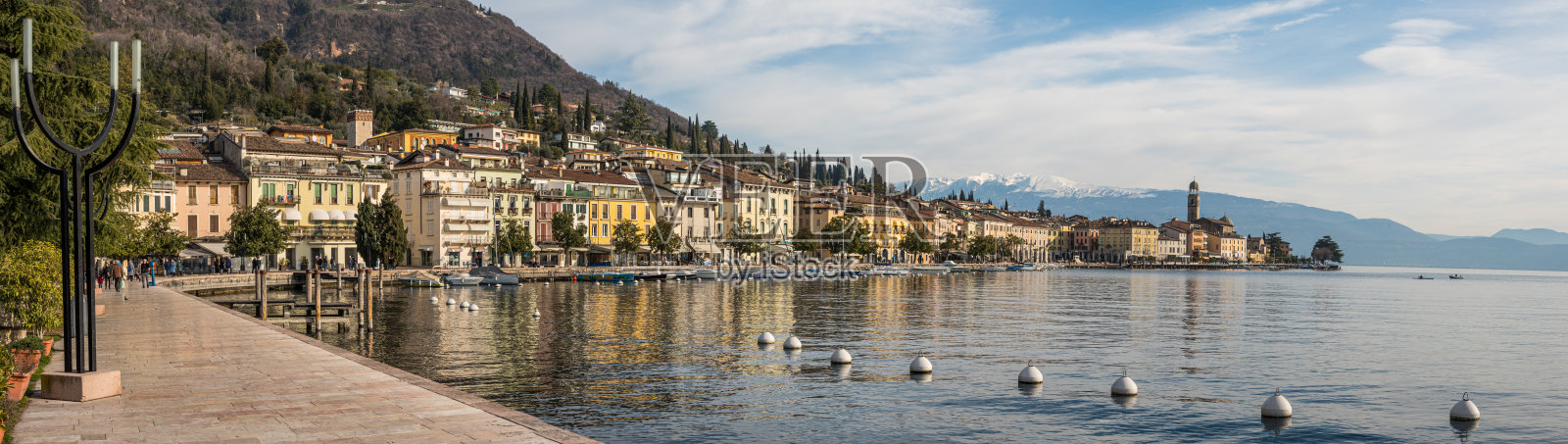 Extra wide view of The beautiful lakeside of Salò with the Lake Garda and the Monte Baldo in background照片摄影图片