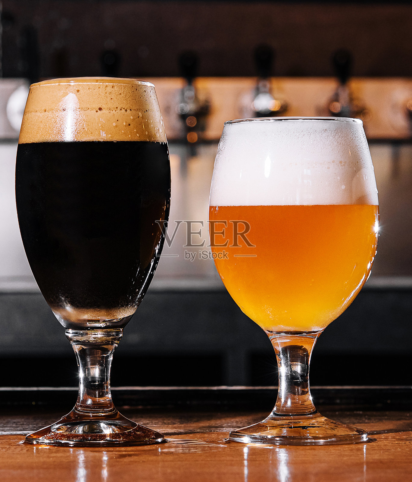 在酒吧内部的桌子上的玻璃杯精酿啤酒照片摄影图片