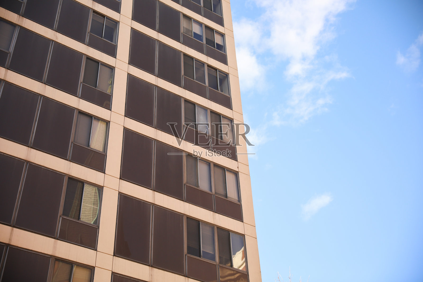 光滑而现代的建筑外观，干净的线条和反射蓝天的大窗户。该建筑的特点是混凝土、钢和玻璃的混合，具有未来主义和复杂的外观照片摄影图片