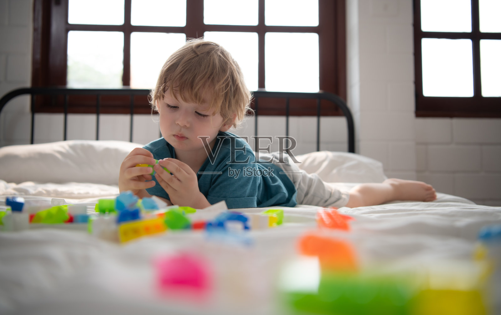 小男孩在他的卧室里拿着一个新玩具照片摄影图片