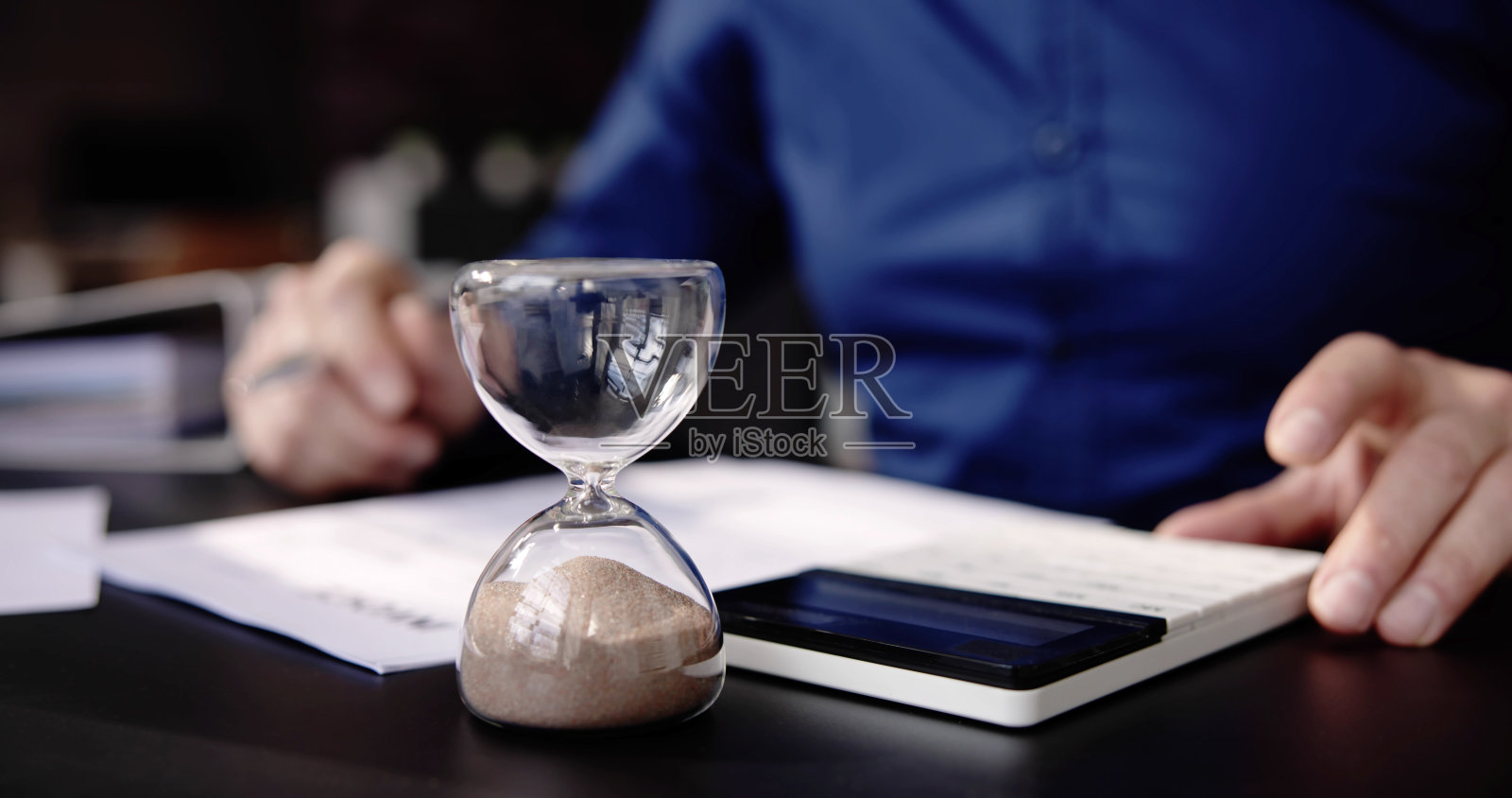 办公桌上的沙漏。发票过期照片摄影图片