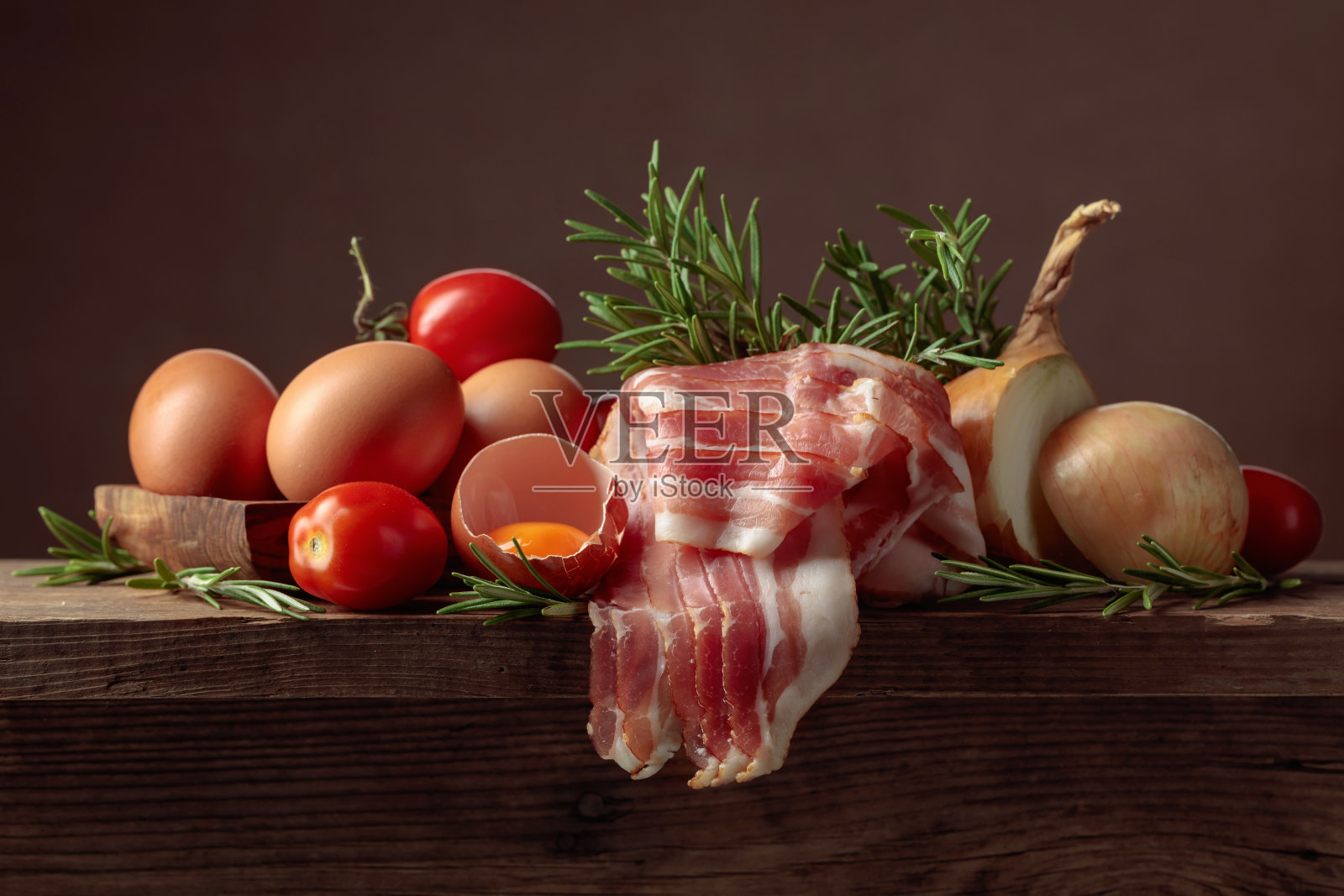 熏肉配鸡蛋、西红柿、洋葱和迷迭香。照片摄影图片