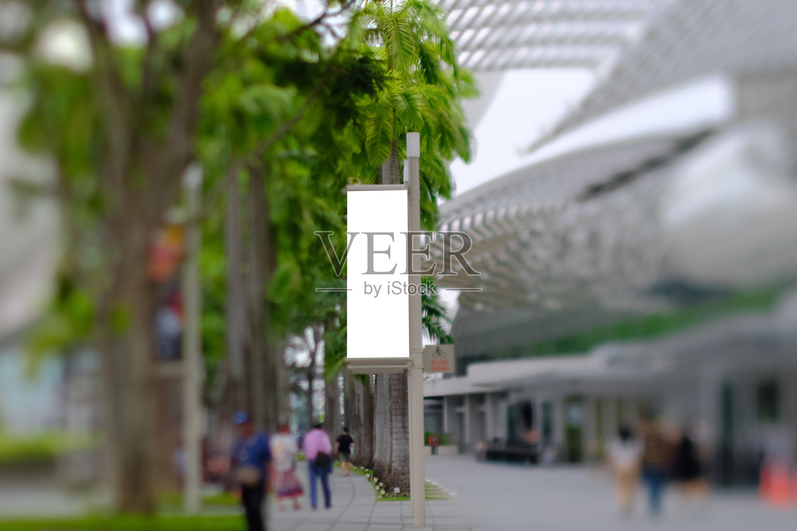 专注于闹市区的空白挂海报模型;街道灯柱垂直广告横幅模板。为户外户外模板模拟。倾斜换挡镜头;有选择性的重点照片摄影图片