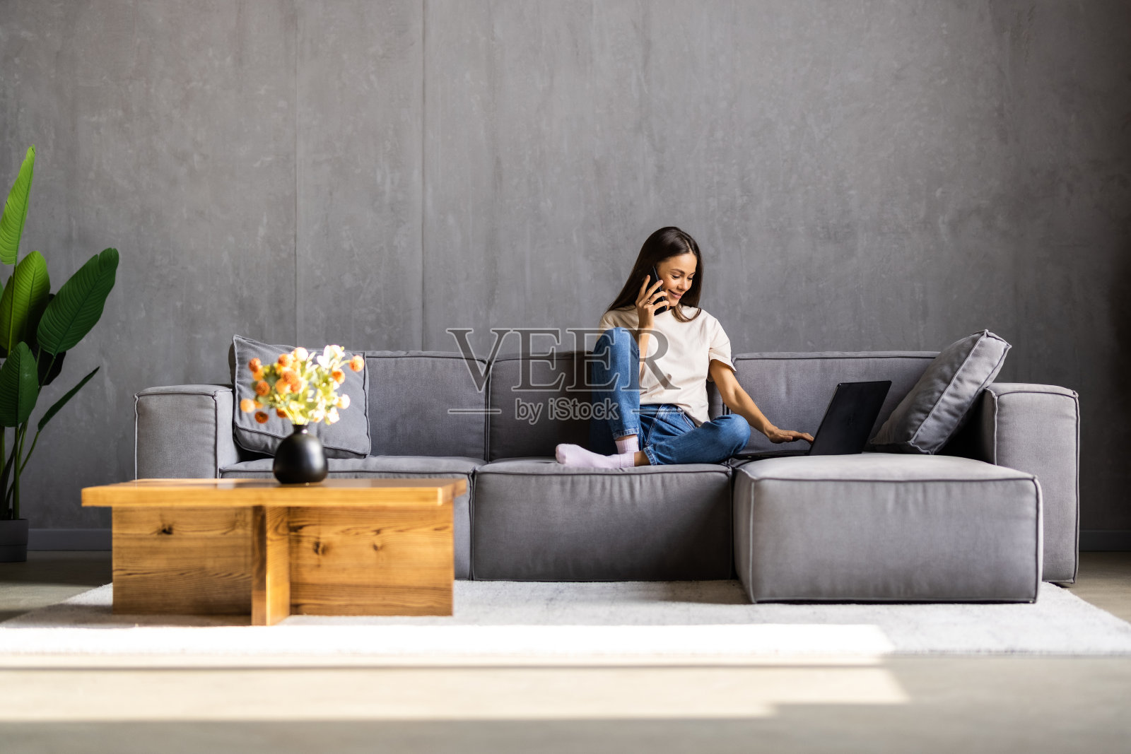 快乐的年轻女子在阁楼公寓打电话照片摄影图片