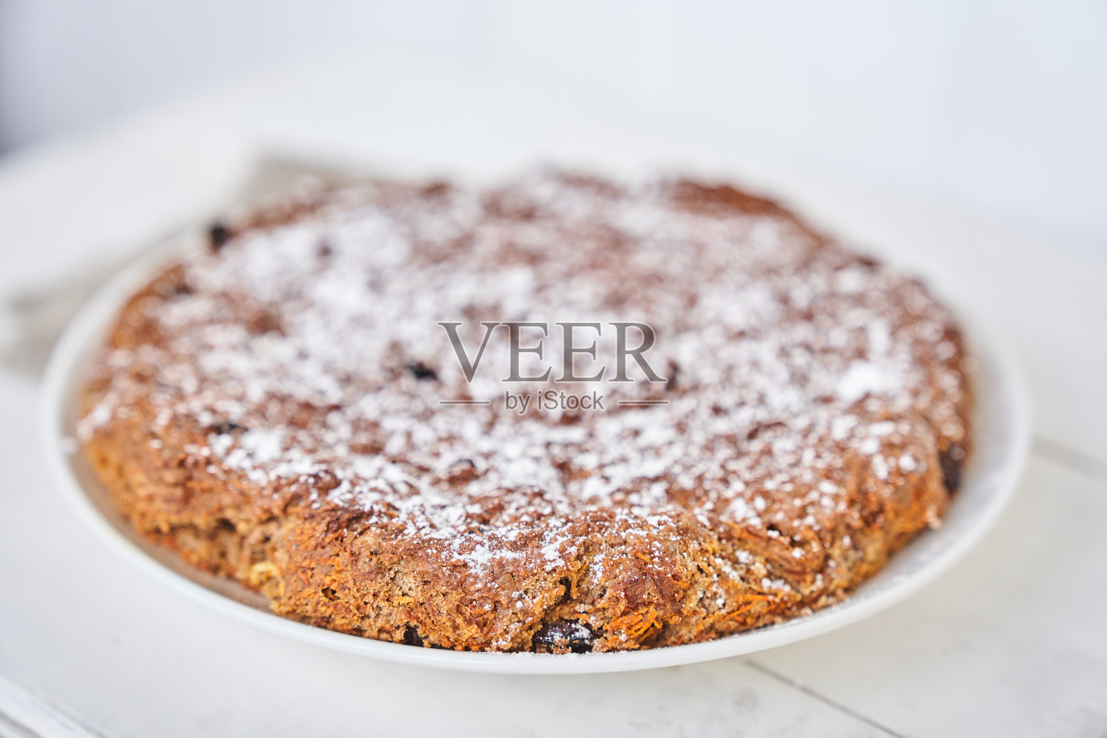 胡萝卜葡萄干派放在白桌子上的盘子里。不含牛奶和鸡蛋的无麸质派。选择性聚焦，文本空间。饮食甜点。健康饮食的概念。高质量照片照片摄影图片