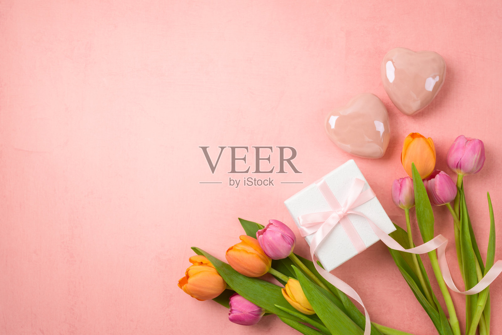 快乐的母亲节概念与郁金香花，心形和礼盒在粉红色的背景。俯视图，平面布局照片摄影图片