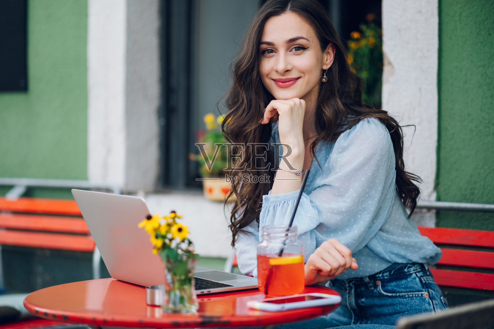 美丽的女人坐在街头咖啡馆和使用笔记本电脑照片摄影图片