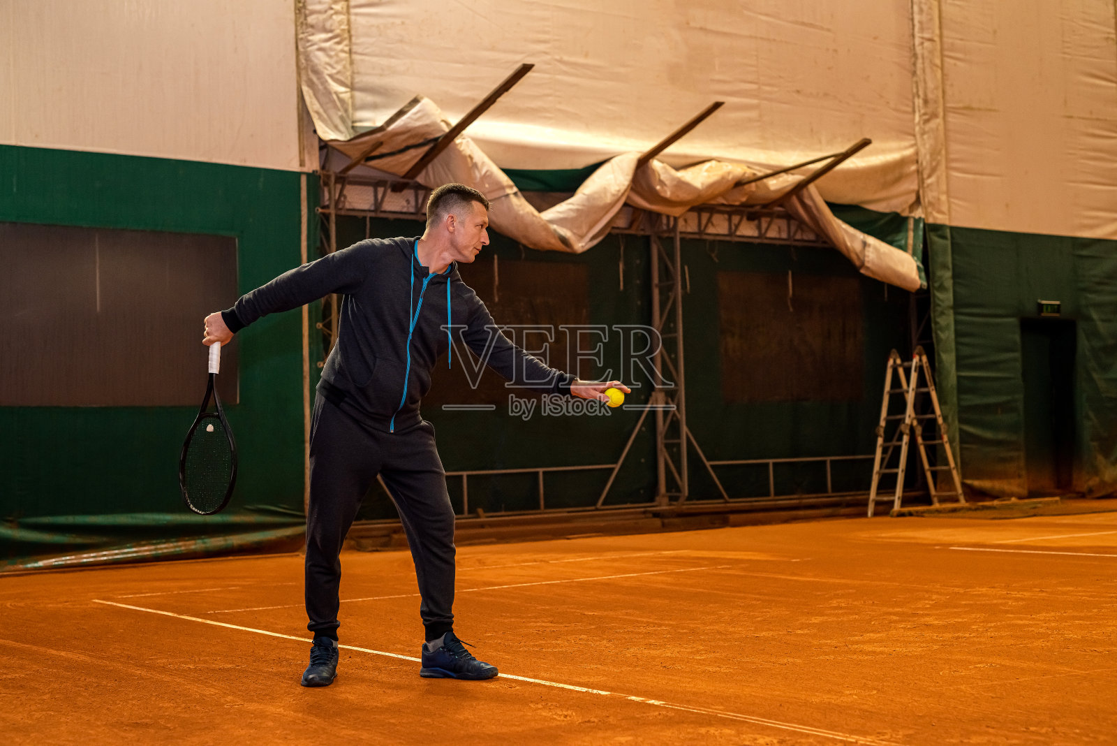 职业网球运动员在室内网球场正手击球。照片摄影图片