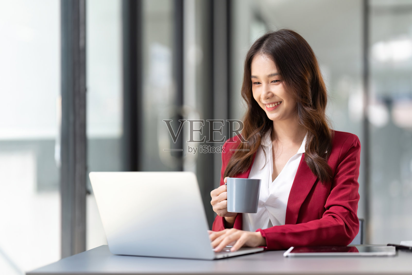 女商人坐在办公室的办公桌前照片摄影图片