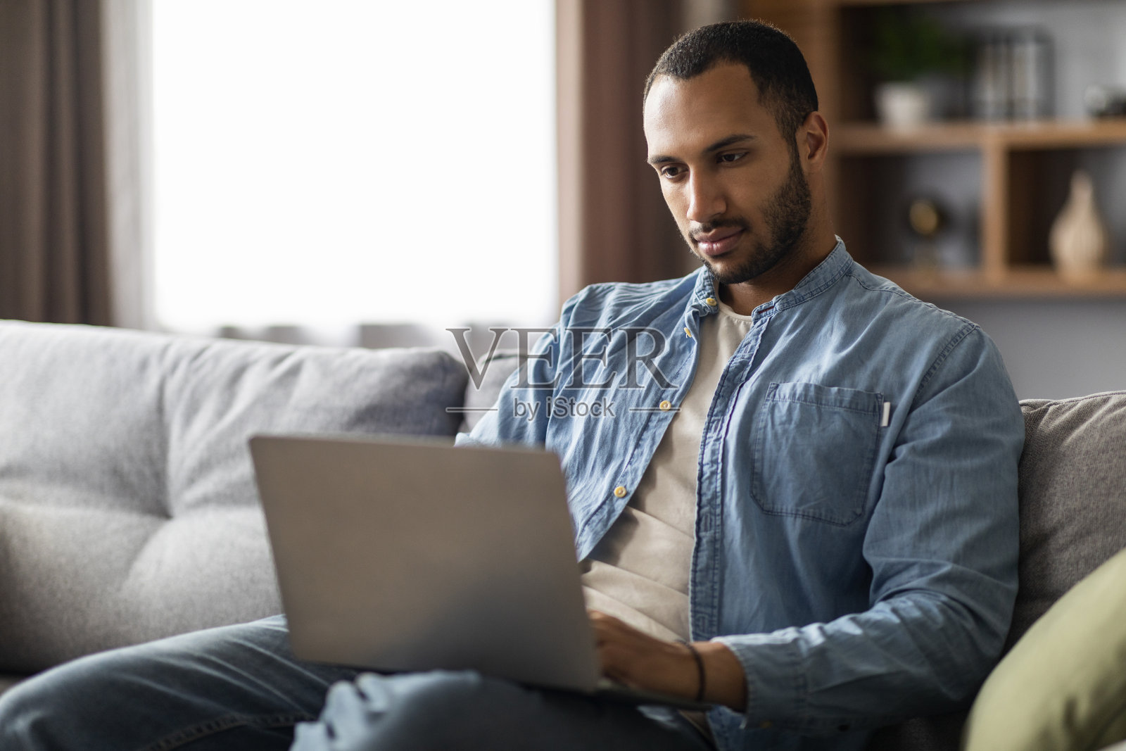 在家用笔记本电脑工作的年轻黑人自由职业者照片摄影图片