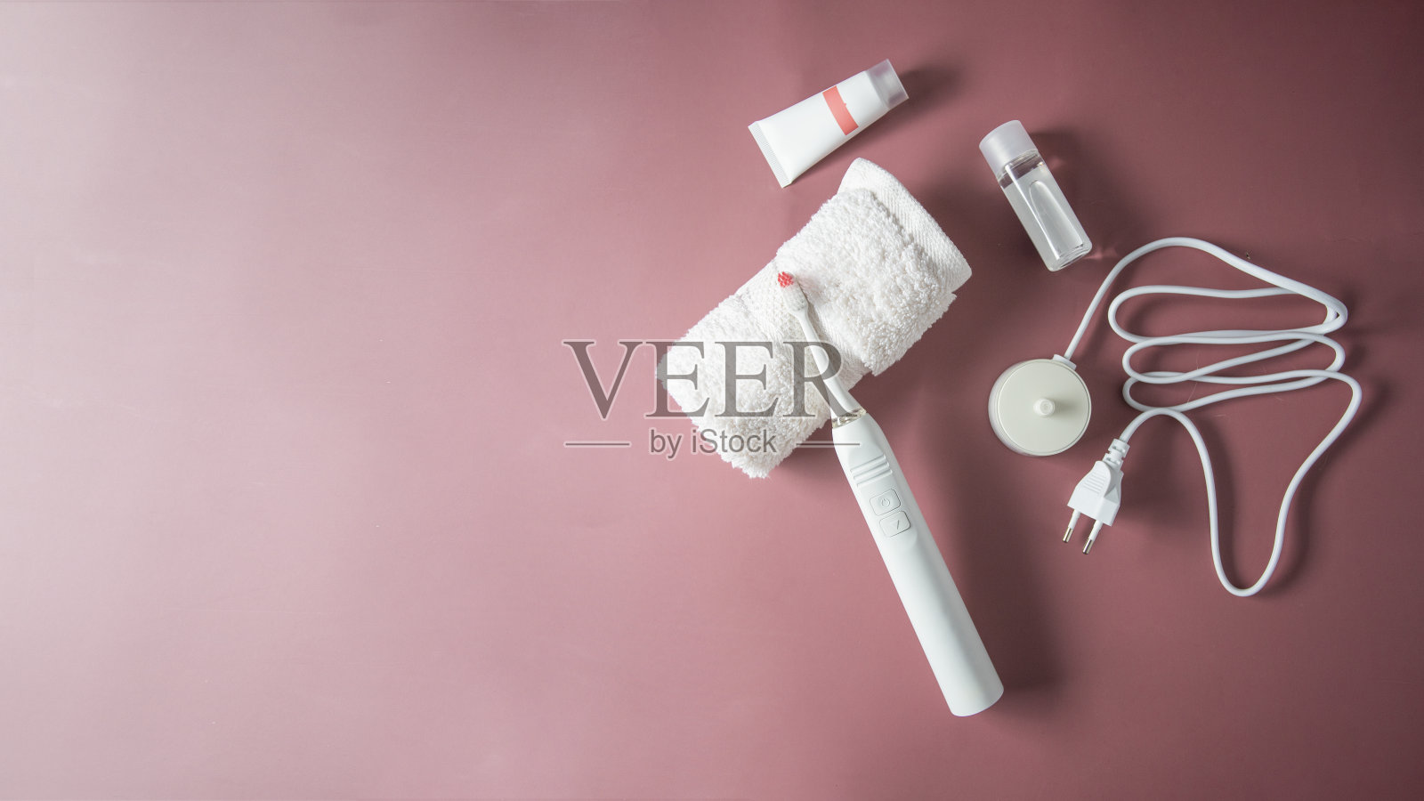 电动牙刷，头刷，充电器，牙膏和漱口水在彩色背景的俯视图。现代口腔护理静物概念。照片摄影图片