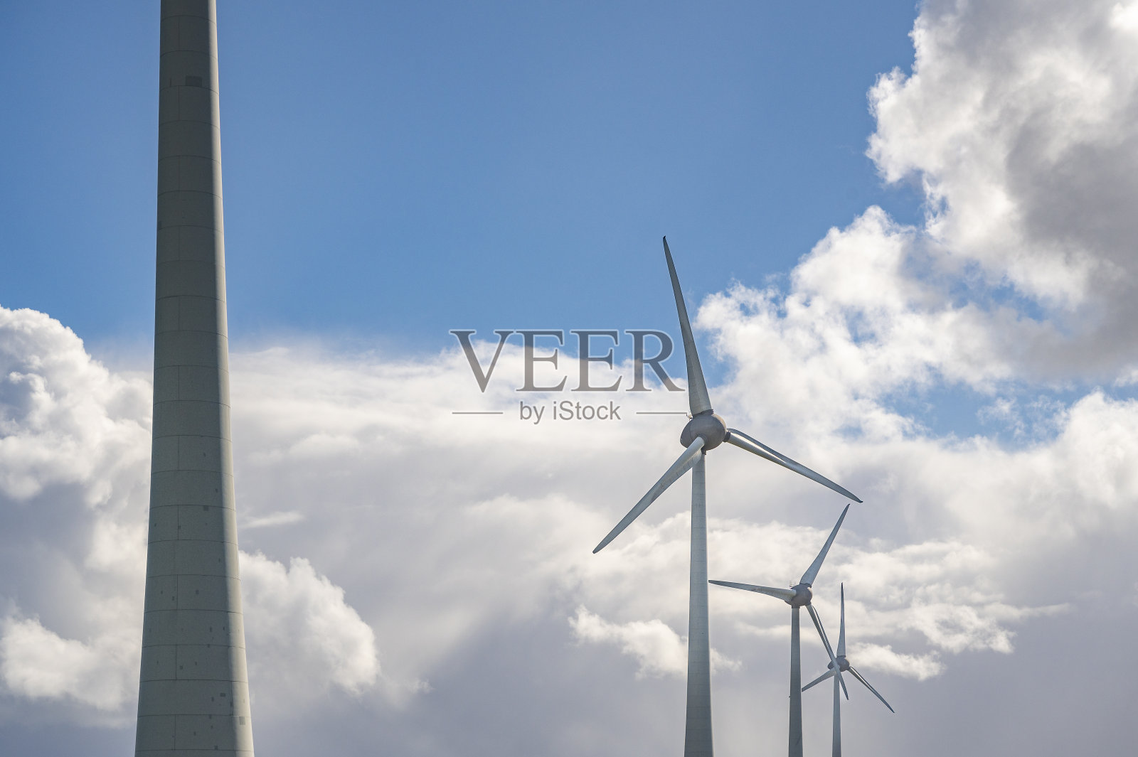 以蓝天白云为背景的风力涡轮机照片摄影图片