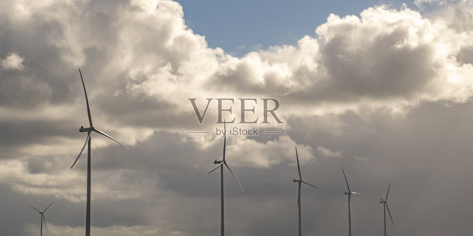 以蓝天白云为背景的风力涡轮机照片摄影图片