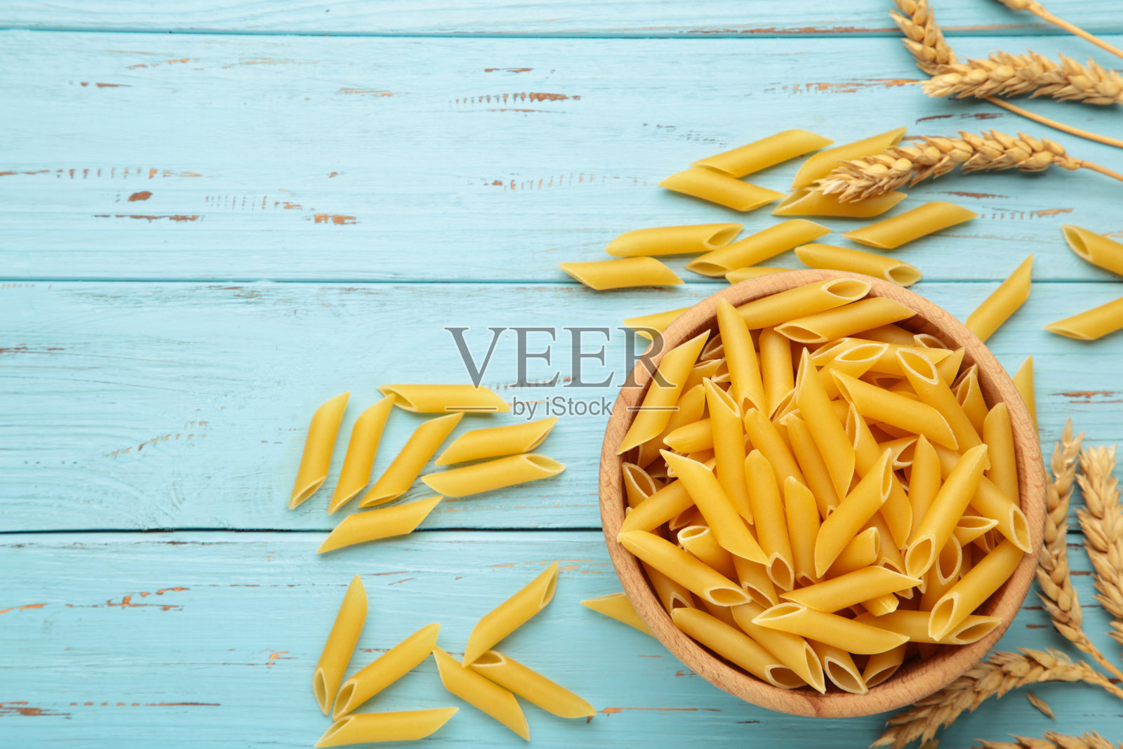 意大利通心粉在碗里，蓝色背景。照片摄影图片