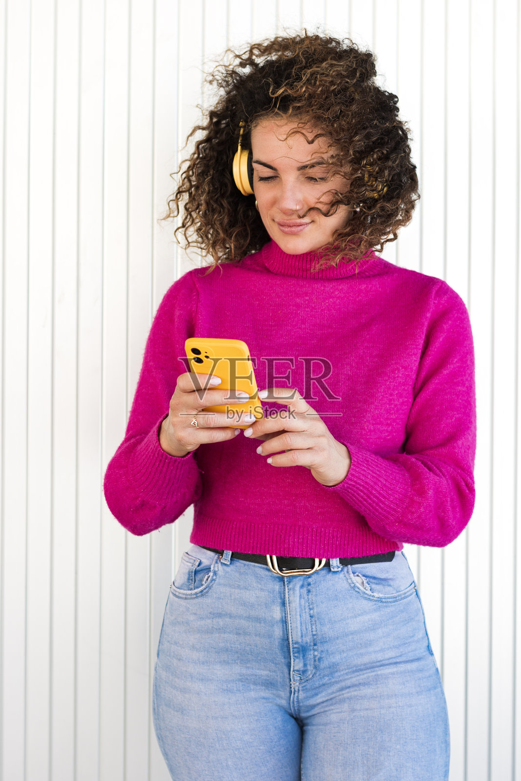 女子戴着耳机使用智能手机照片摄影图片