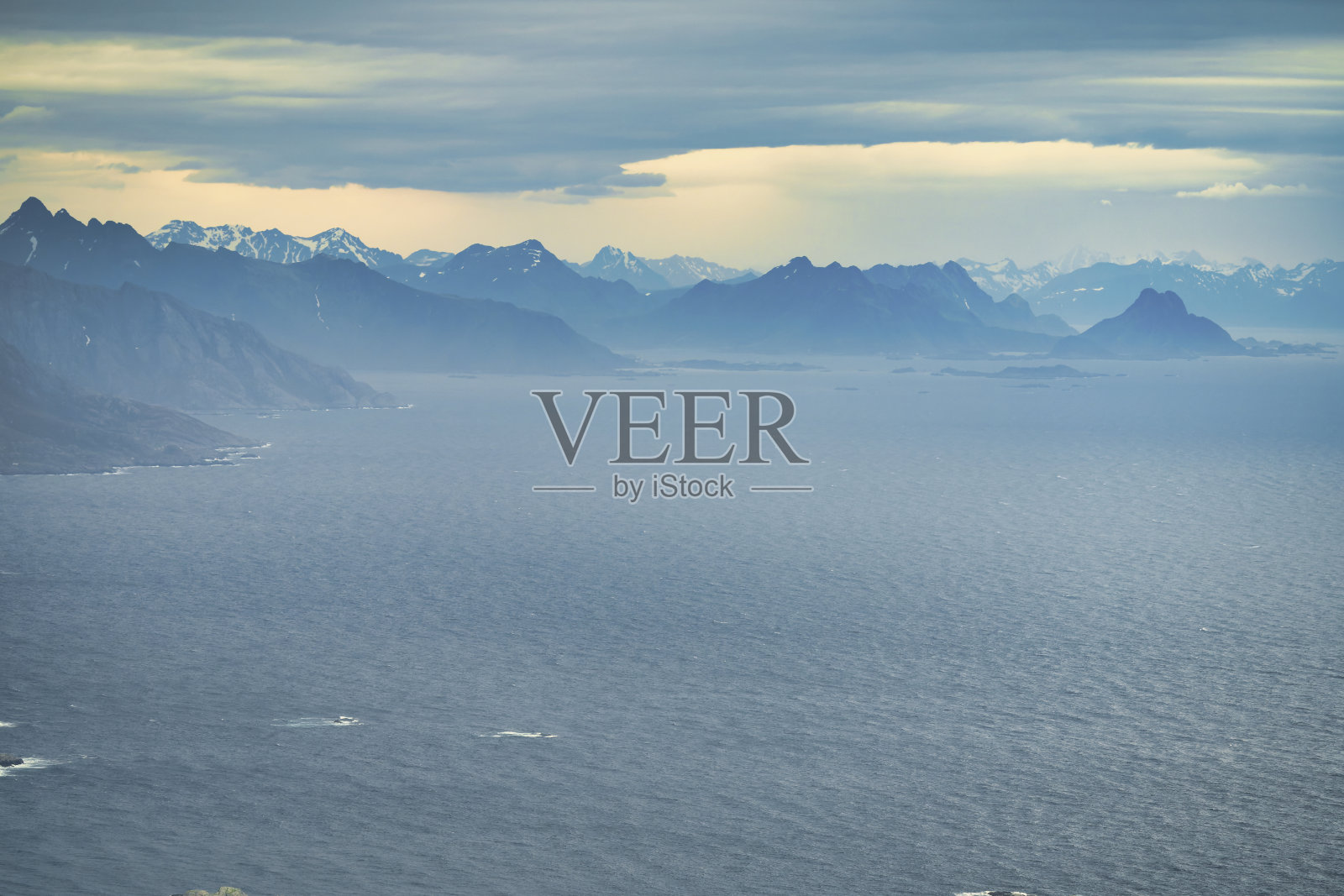 来自挪威罗弗敦岛赖纳的山景，在一个晴朗的春日俯瞰湖泊照片摄影图片