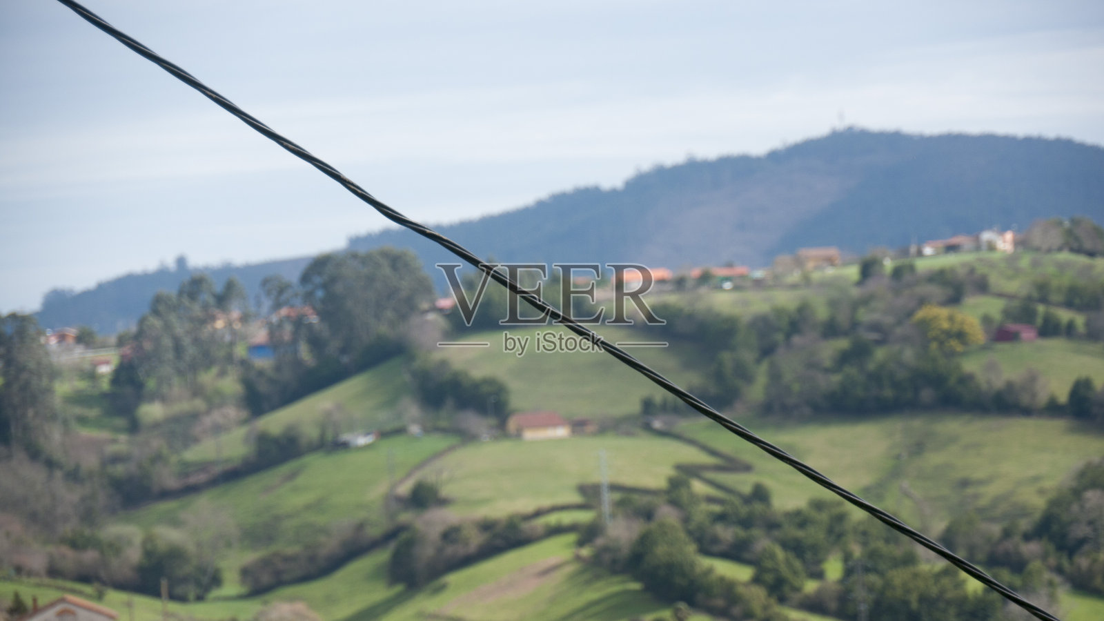 在农田山丘上穿过电线照片摄影图片