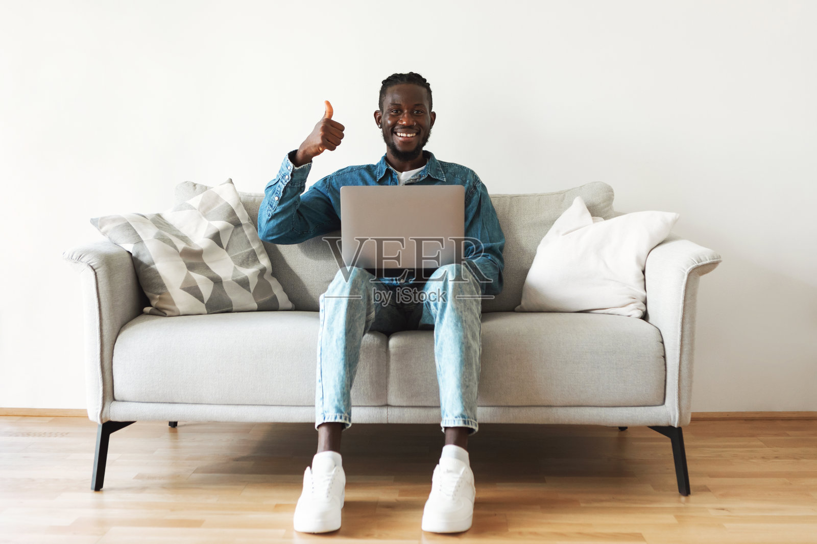 非裔美国男性自由职业者在室内使用笔记本电脑竖起大拇指照片摄影图片