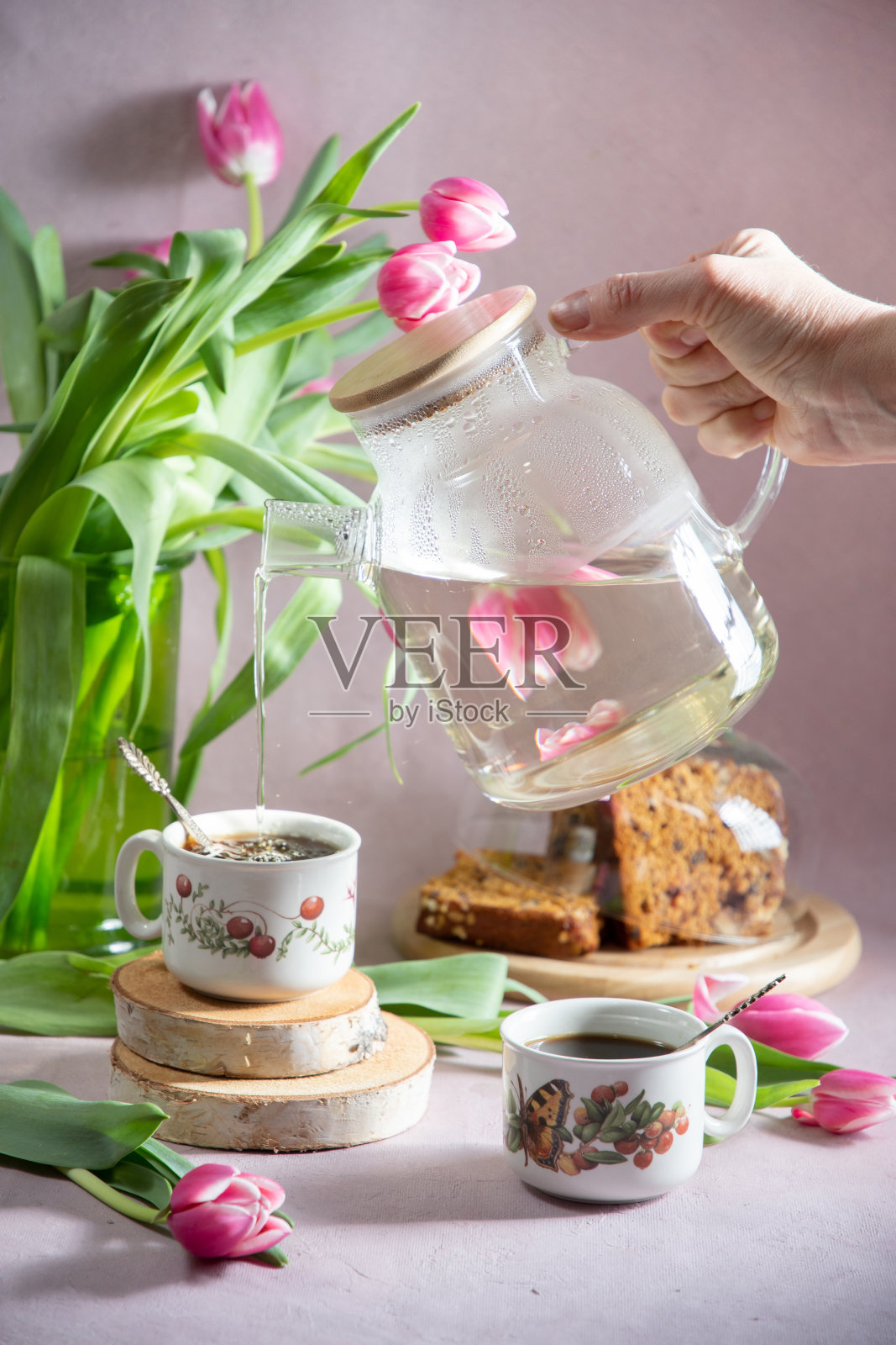 早春早餐的静物早午餐，咖啡或茶，纸杯蛋糕的背景是一束粉红色的郁金香照片摄影图片