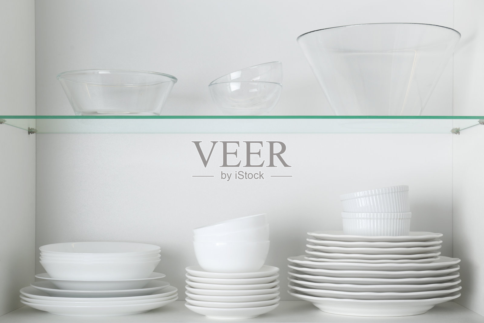 不同的干净盘子和碗在柜子的架子上照片摄影图片