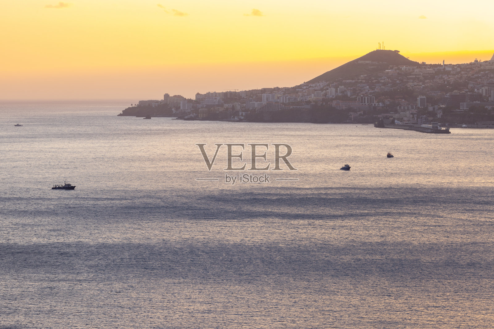 伟大的无人机在美丽的春天日落的海面上拍摄，前景中有一些船。照片摄影图片